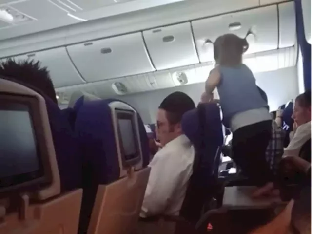 Parents slammed after video of their toddler 'running wild' on an eight-hour flight is debated | Business Insider